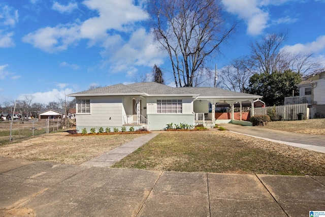 ranch-style home featuring a front lawn and a carport