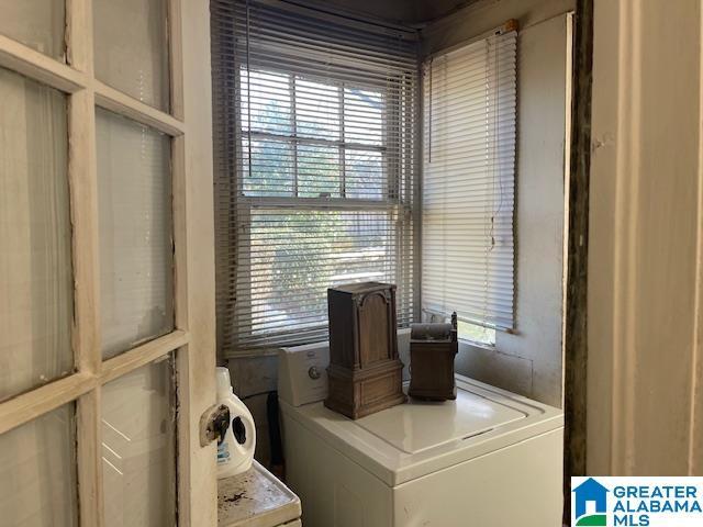 clothes washing area with separate washer and dryer and cabinets