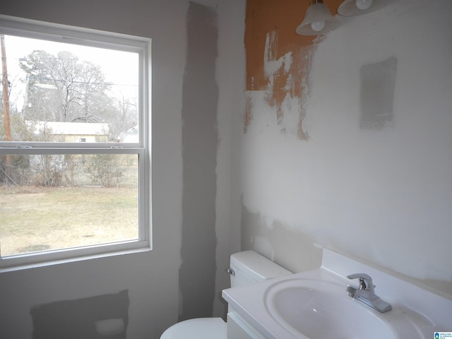 bathroom with vanity, a wealth of natural light, and toilet