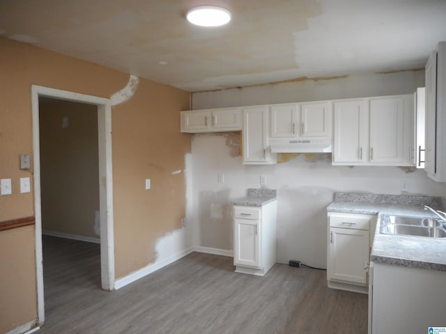 kitchen featuring sink, white cabinets, and light wood-type flooring