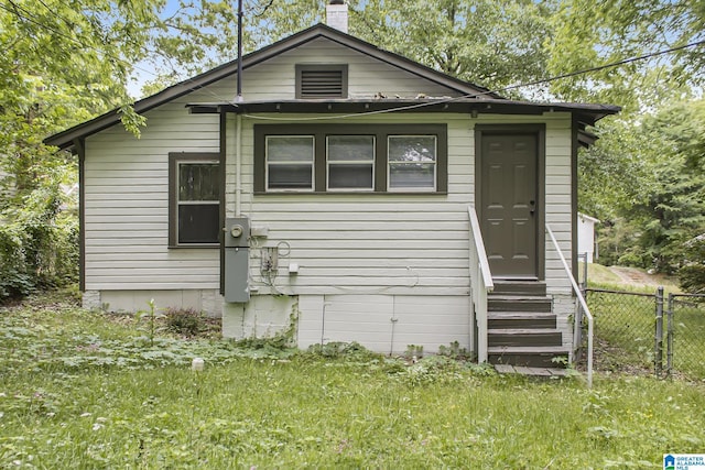 rear view of house featuring a lawn