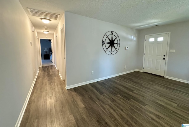 foyer with a textured ceiling and dark hardwood / wood-style flooring