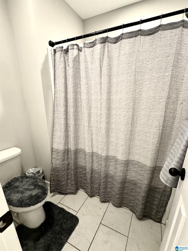 bathroom with toilet and a shower with shower curtain