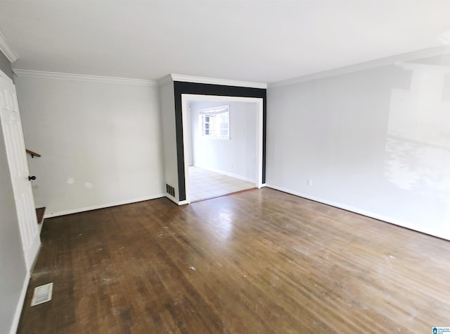 empty room with hardwood / wood-style floors and crown molding