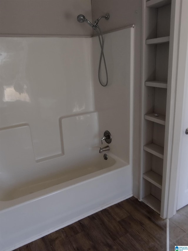 bathroom featuring hardwood / wood-style floors, built in features, and shower / bathtub combination