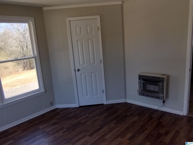 spare room featuring dark hardwood / wood-style floors and heating unit