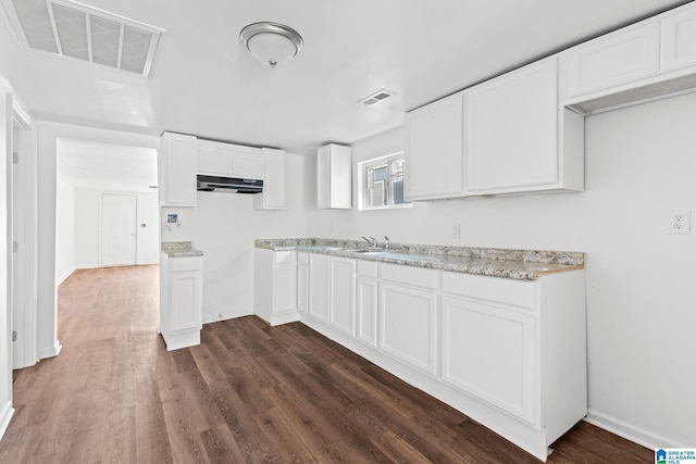 kitchen featuring white cabinetry, dark hardwood / wood-style flooring, sink, and light stone counters