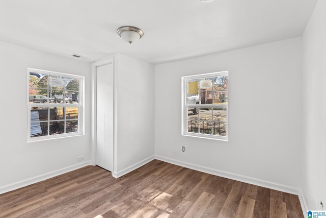 unfurnished room with hardwood / wood-style floors and plenty of natural light