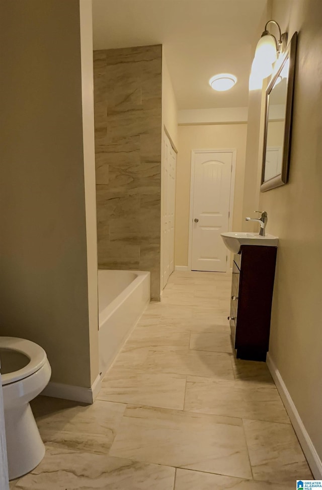 bathroom featuring vanity, toilet, and a washtub