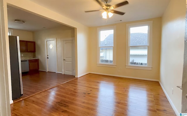 unfurnished living room with ceiling fan, a mountain view, and light hardwood / wood-style floors