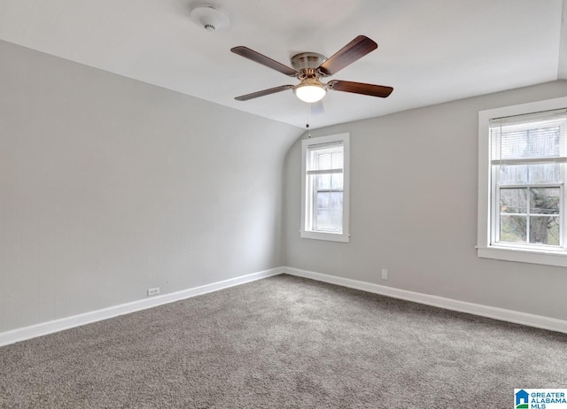 carpeted empty room featuring lofted ceiling and ceiling fan