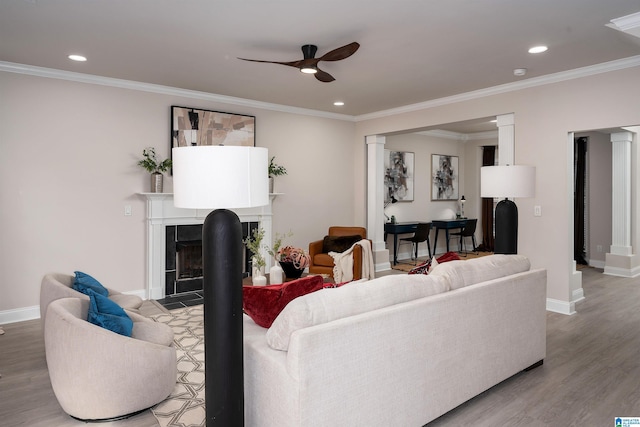 living room with hardwood / wood-style floors, ornamental molding, ceiling fan, and ornate columns