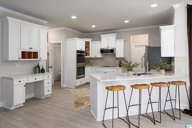 kitchen featuring stainless steel appliances, white cabinetry, and kitchen peninsula