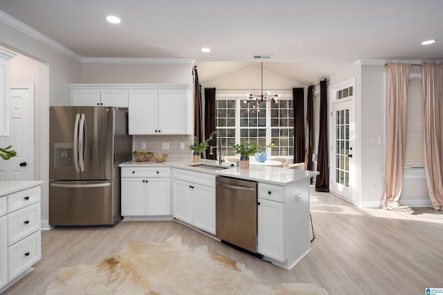 kitchen featuring white cabinetry, appliances with stainless steel finishes, sink, and pendant lighting