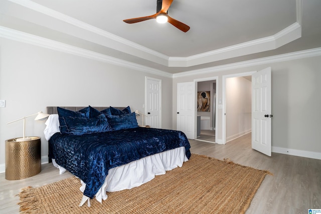 bedroom featuring a raised ceiling, crown molding, hardwood / wood-style floors, and ceiling fan