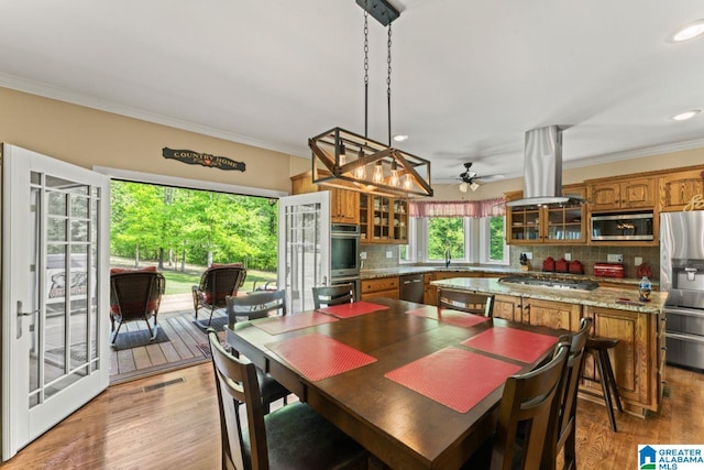 dining area with sink, crown molding, light hardwood / wood-style flooring, and ceiling fan