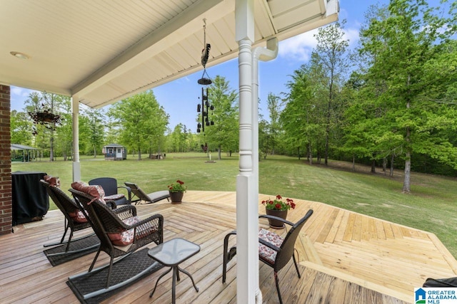 wooden deck featuring a storage shed and a lawn