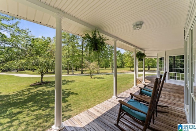 deck featuring covered porch and a lawn