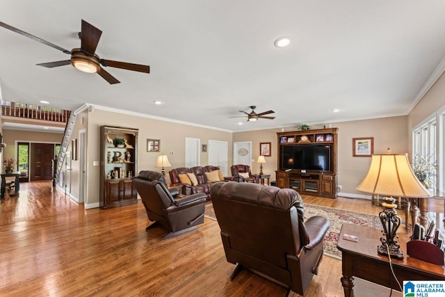 living room featuring hardwood / wood-style flooring, ornamental molding, and a healthy amount of sunlight