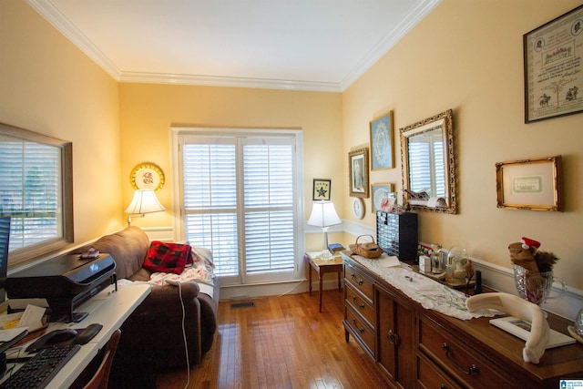 living area featuring ornamental molding, plenty of natural light, and light hardwood / wood-style flooring