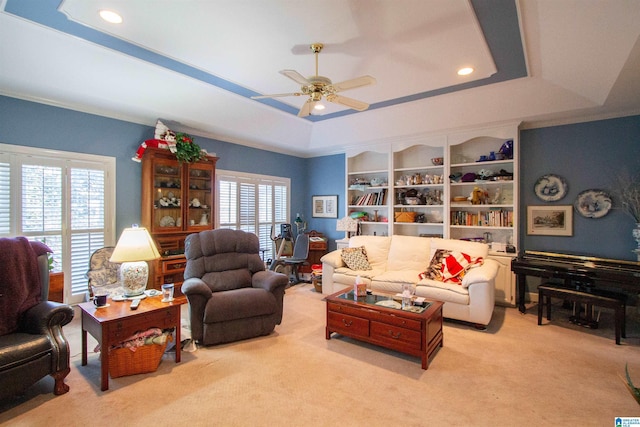 living room with a tray ceiling, plenty of natural light, and light colored carpet