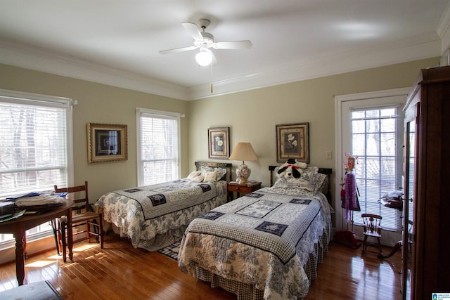 bedroom with crown molding, ceiling fan, and dark hardwood / wood-style flooring