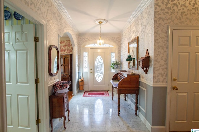 entryway featuring ornamental molding and an inviting chandelier