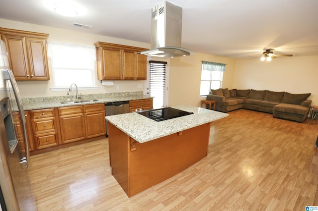 kitchen with sink, stainless steel appliances, island range hood, light hardwood / wood-style floors, and a kitchen island