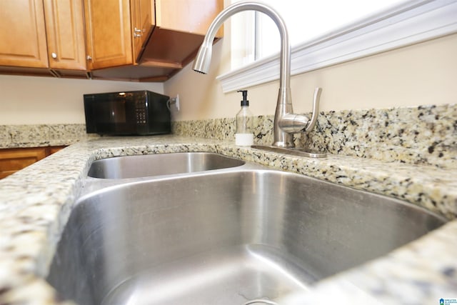 interior details with light stone countertops and sink