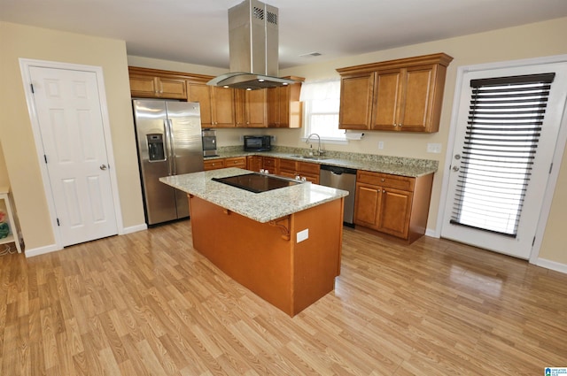 kitchen with sink, island range hood, a center island, light stone countertops, and black appliances