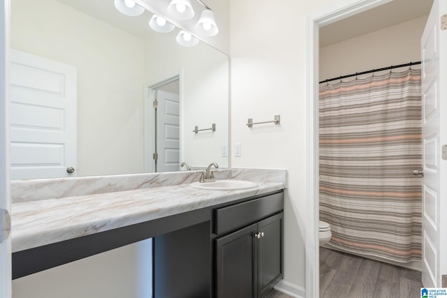 bathroom featuring hardwood / wood-style flooring, vanity, and toilet