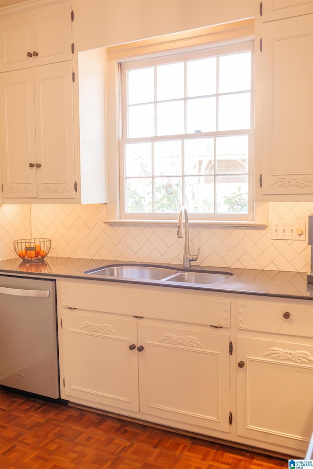 kitchen with dark parquet flooring, dishwasher, sink, and white cabinets