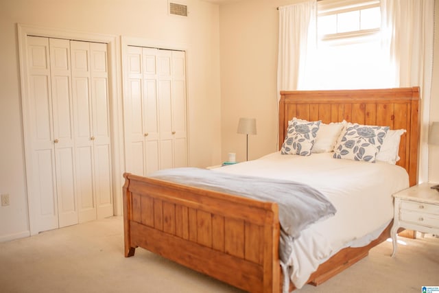 carpeted bedroom with two closets