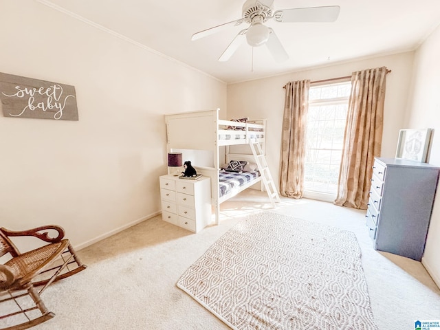 carpeted bedroom featuring crown molding and ceiling fan