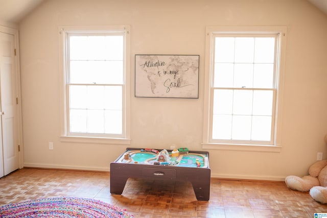 recreation room featuring lofted ceiling and a healthy amount of sunlight