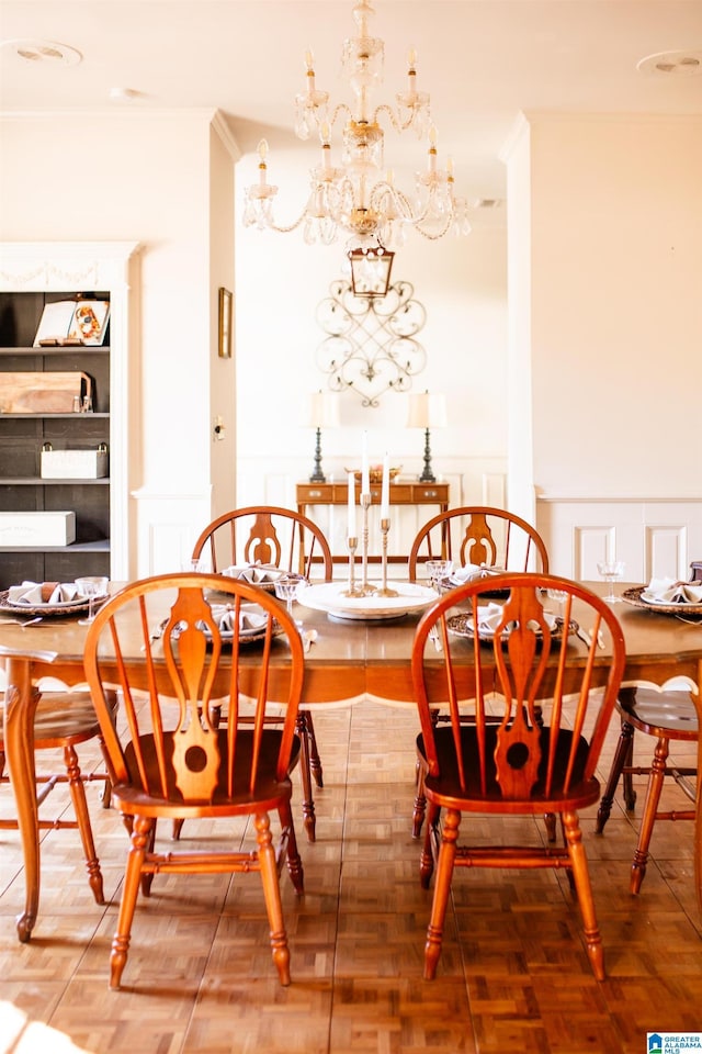 dining space featuring a notable chandelier, crown molding, and parquet flooring