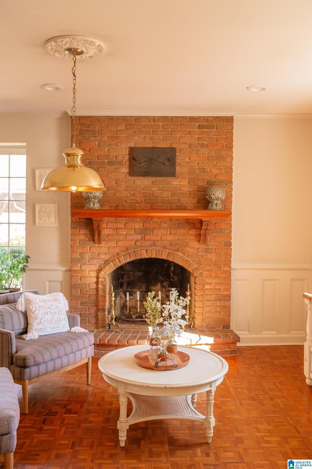 living area with crown molding, parquet flooring, and a fireplace