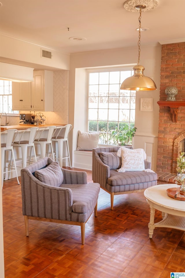 living room featuring dark parquet flooring, a brick fireplace, sink, and a wealth of natural light