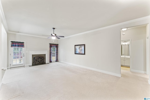 unfurnished living room featuring baseboards, light colored carpet, ceiling fan, ornamental molding, and a high end fireplace