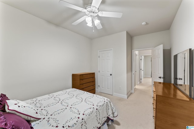 bedroom featuring baseboards, a ceiling fan, and light colored carpet