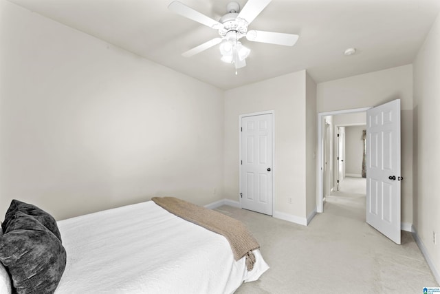 bedroom featuring a ceiling fan, light colored carpet, and baseboards