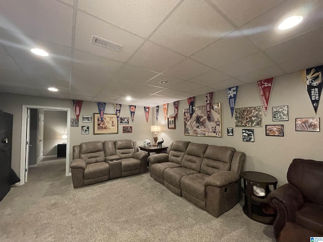 carpeted living room featuring a drop ceiling