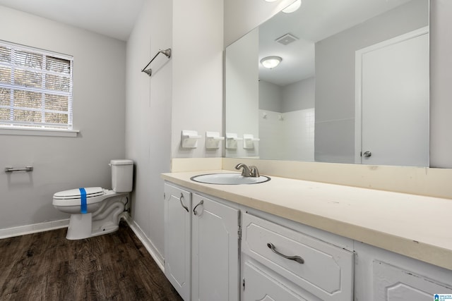 bathroom featuring vanity, hardwood / wood-style floors, toilet, and walk in shower