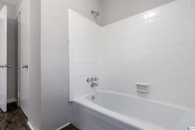 bathroom with wood-type flooring and tiled shower / bath