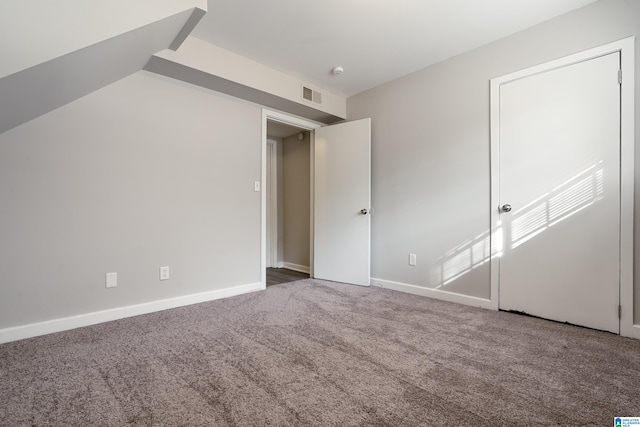 unfurnished bedroom with vaulted ceiling and carpet floors