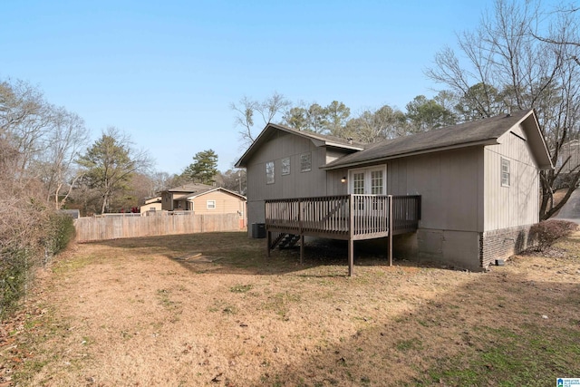 rear view of house featuring a deck, a lawn, and central air condition unit