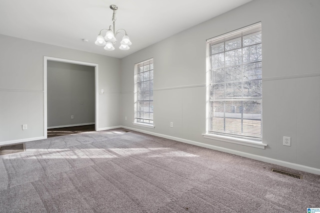 unfurnished room with carpet floors and an inviting chandelier