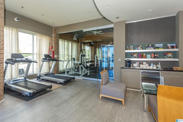 gym featuring wood-type flooring and brick wall