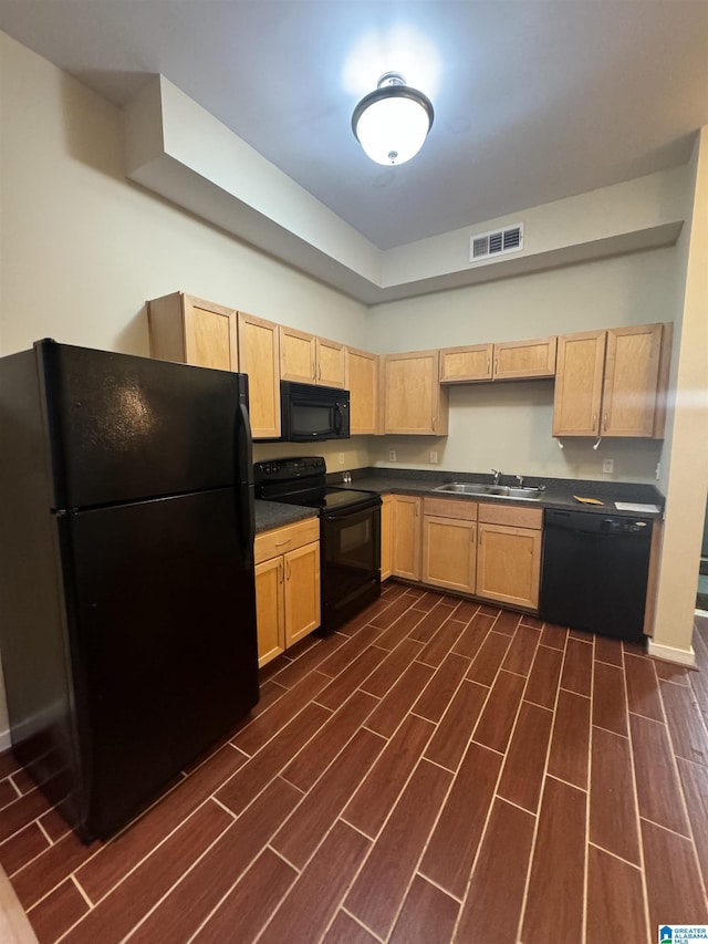 kitchen featuring sink, light brown cabinetry, and black appliances