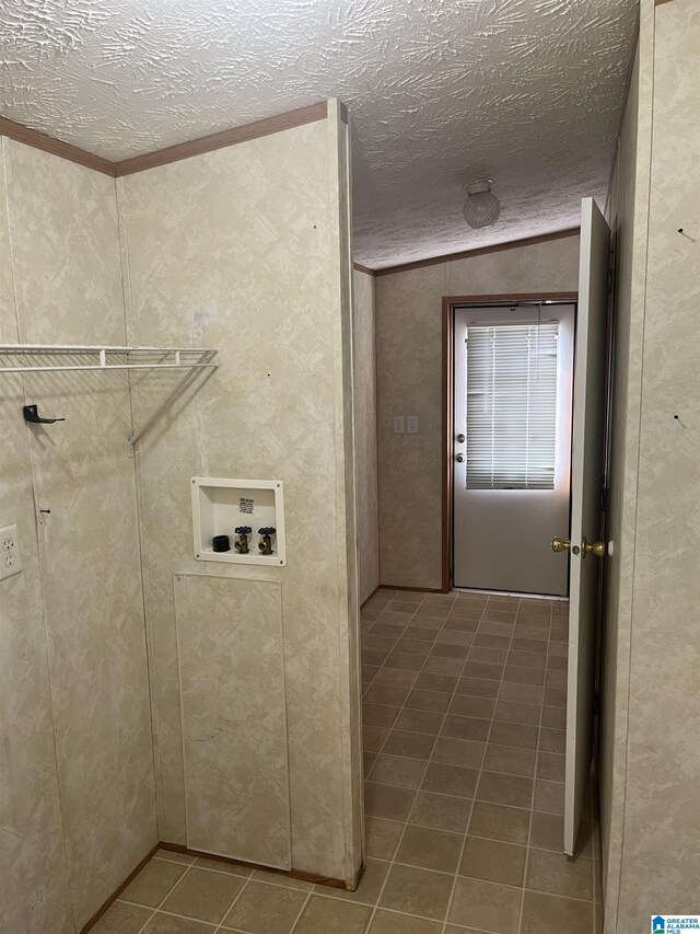 laundry room with washer hookup, tile patterned floors, and a textured ceiling